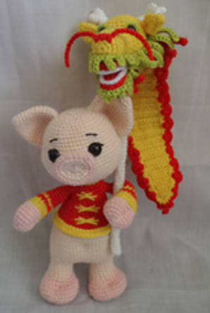 Amigurumi pig holding a dragon